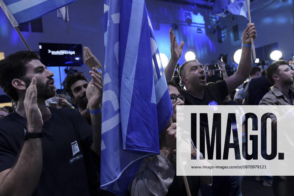 Yashar Supporters Celebrate Exit Polls A Yashar supporter wearing a party badge raises an arm and shouts while another man claps beside a cluster of party flags in Tel Aviv, Israel, on October 27, 2026. Supporters of Yashar, the party led by former Israeli military chief Gadi Eisenkot, gathered in Tel Aviv as initial exit polls were released following voting in the 26th Knesset election. Tel Aviv Tel Aviv Israel
