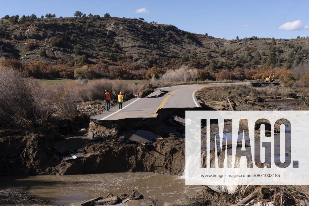 Workers walk along a collapsed section of Colorado 151 as seen on Oct. 27, 2026, between Pagosa Springs and Ignacio. Recent heavy rains have caused severe flooding across southwestern Colorado, forcing evacuations and damaging roads and homes. Pagosa Springs USA - ZUMAc262 20261027_znn_c262_001