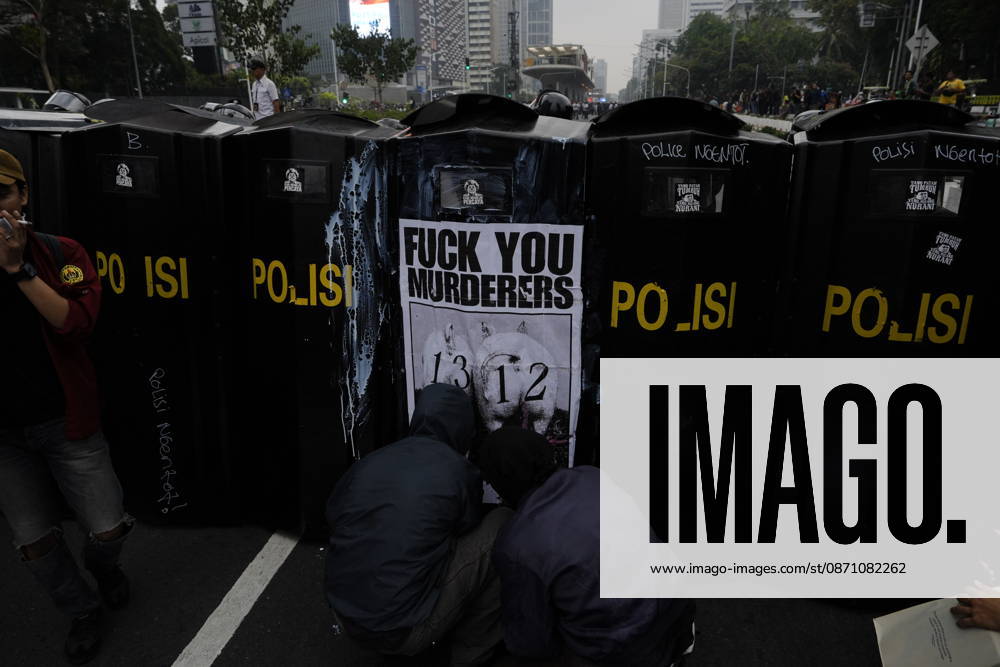 Student protesters crouch in front of police riot shields bearing a poster reading Ã¢â‚¬oeFuck You MurderersÃ¢â‚¬Â during a demonstration at Bundaran HI Jakarta Indonesia - ZUMAm265 20261028_zip_m265_019