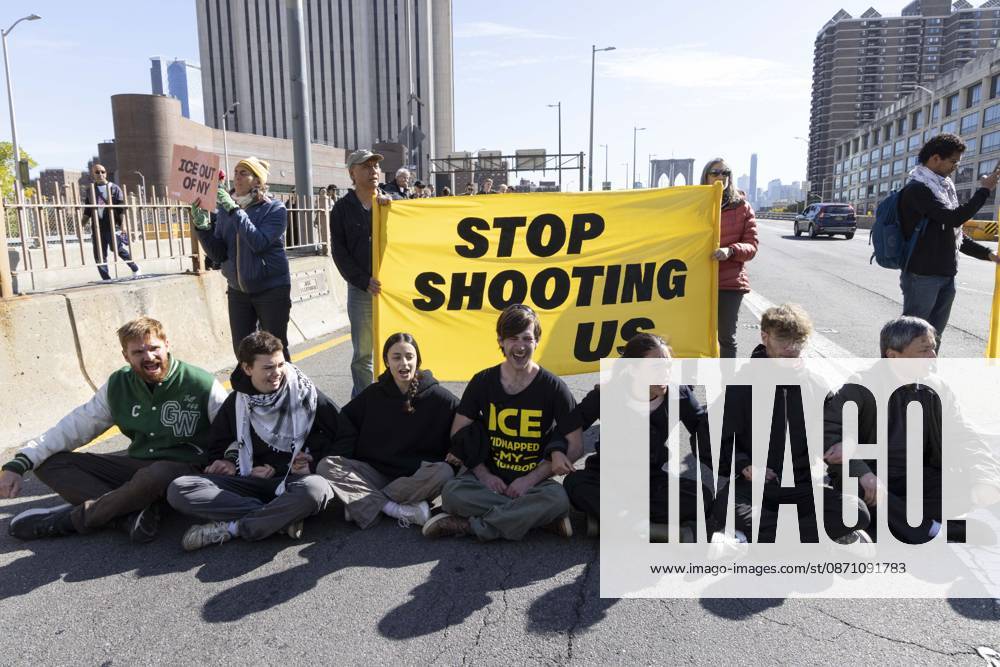 Anti-ICE (U.S. Immigration and Customs Enforcement) demonstrators sit in the roadway on the Brooklyn Bridge with a banner that reads STOP SHOOTING US protesting the continued detainment of O. Belgal, who was shot by federal agents in the Bronx with his 5-yr-old son in the car. The demonstration stopped Brooklyn bound traffic and results in arrests by NYPD. Protesters call for ICE out of New York. New York USA - ZUMAr174 20261028_znp_r174_001