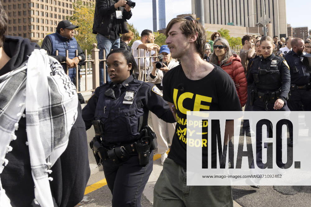 Anti-ICE (U.S. Immigration and Customs Enforcement) demonstrators are arrested by NYPD after blockading the roadway and stopping traffic on the Brooklyn Bridge protesting the continued detainment of O. Belgal, who was shot by federal agents in the Bronx with his 5-yr-old son in the car. A protester wears a shirt that reads ICE KIDNAPPED MY NEIGHBOR. Protesters call for ICE out of New York. New York USA - ZUMAr174 20261028_znp_r174_023