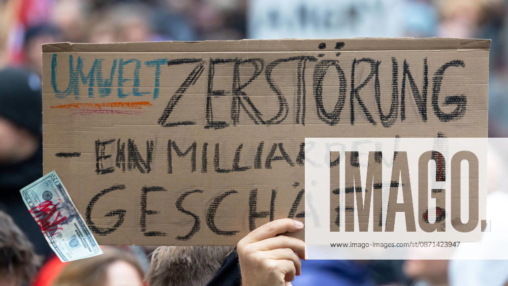 Gen Z Takes Charge: Hundreds March Through the Old Town and Südstadt, Nuremberg, October 31, 2026: At a rally organized by the Gen Z Regelt initiative, a protester holds up a cardboard sign reading Environmental destruction is a billion-dollar business. The nationwide init 20261031-1V9A3921-M4000