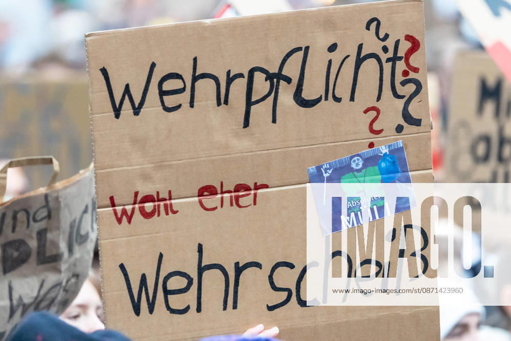 Gen Z Takes Charge: Hundreds March Through the Old Town and Südstadt, Nuremberg, October 31, 2026. At a rally organized by the Gen Z Takes Charge initiative, a protester holds up a cardboard sign reading Conscription, More like military bullshit! The nationwide initiative opposes conscription and austerity measures that burd 20261031-1V9A3957-M4000