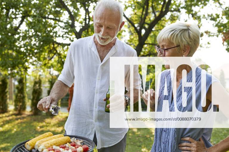 Senior couple having a barbecue in garden model released Symbolfoto property released ZEDF01597