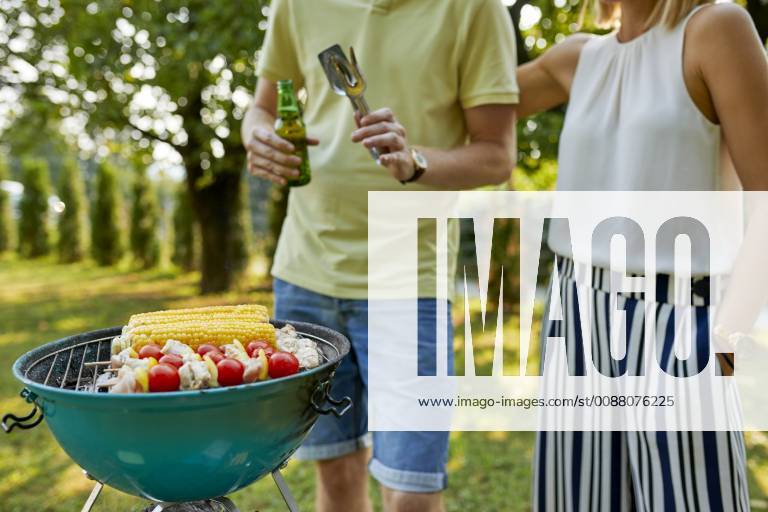 Young couple having a barbecue in garden model released Symbolfoto property released ZEDF01587