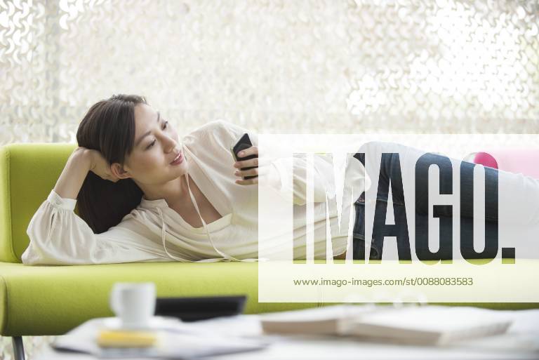 Woman relaxing at home using smartphone