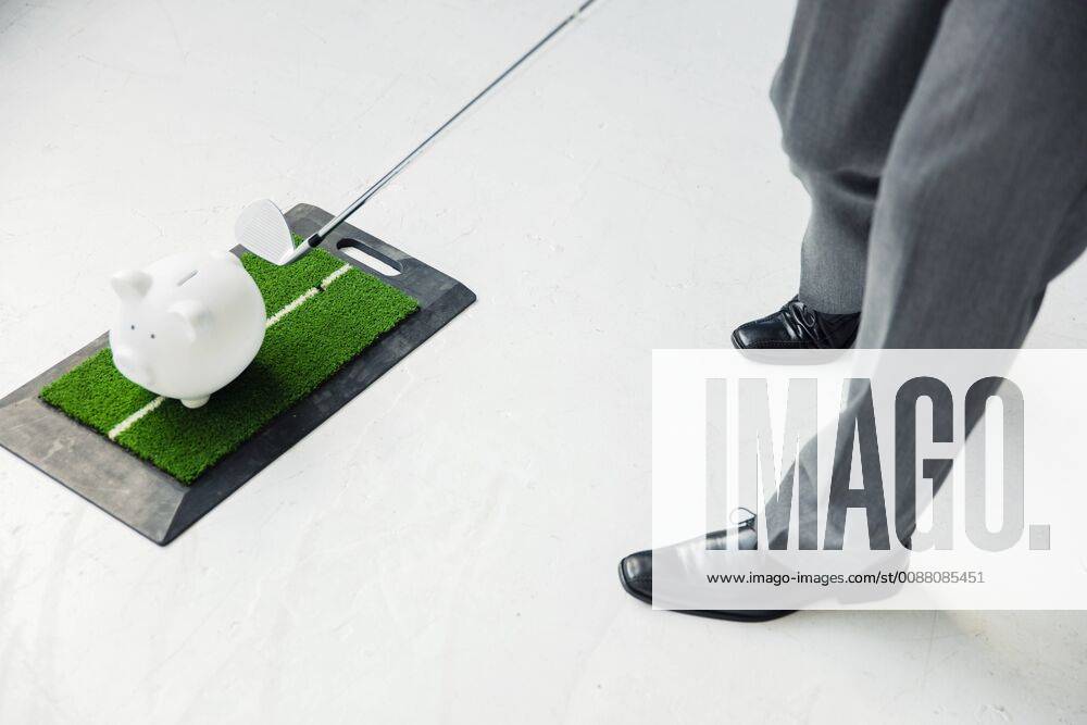 Close-up of businessman playing golf with piggy bank model released Symbolfoto property released MOEF01464