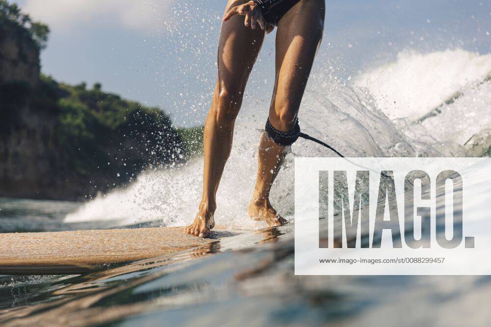 Low section shot of woman surfing, Kuta, Lombok, Indonesia, Kuta Lombok Indonesia model released Symbolfoto