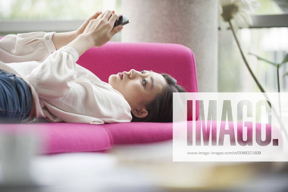 Woman relaxing at home using smartphone