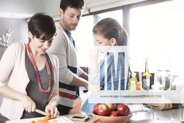 Family preparing food together in kitchen