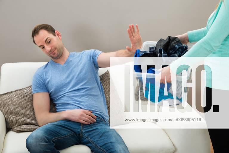 Man Ignoring Dirty Clothes Hold By A Woman model released Symbolfoto