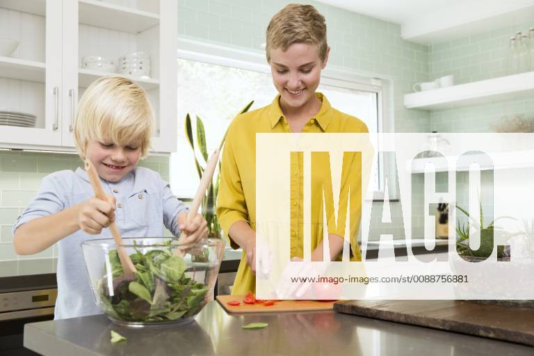 Smiling mother and son preparing salad in kitchen together model released Symbolfoto property released MFRF01070
