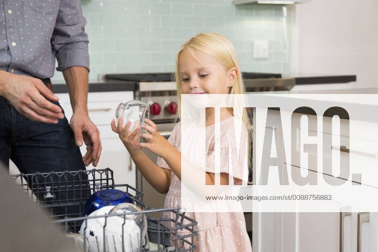 Girl helping father clearing the dishwasher in kitchen model released Symbolfoto property released MFRF01084