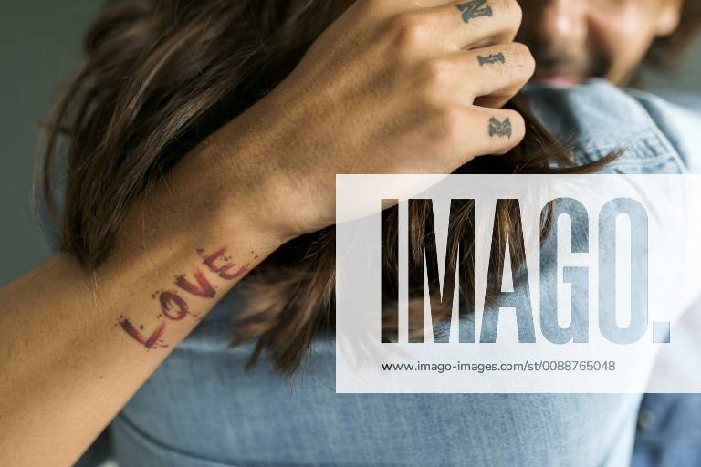 Close-up of tattooed man embracing girlfriend model released Symbolfoto property released VABF01804