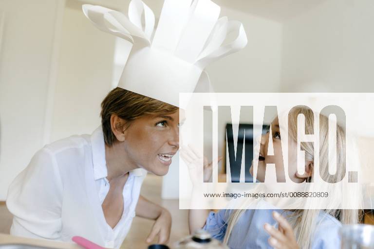 Happy mother and daughter playing at home putting on chef s hat model released Symbolfoto property released KNSF05042