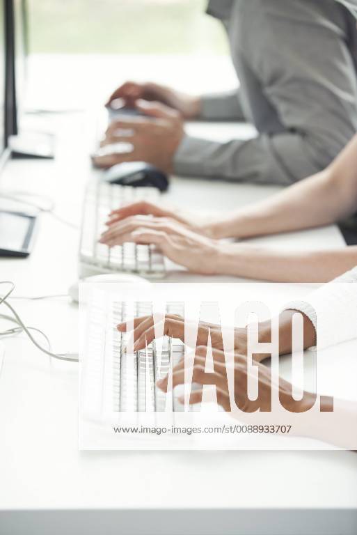 Office workers using computer keyboards