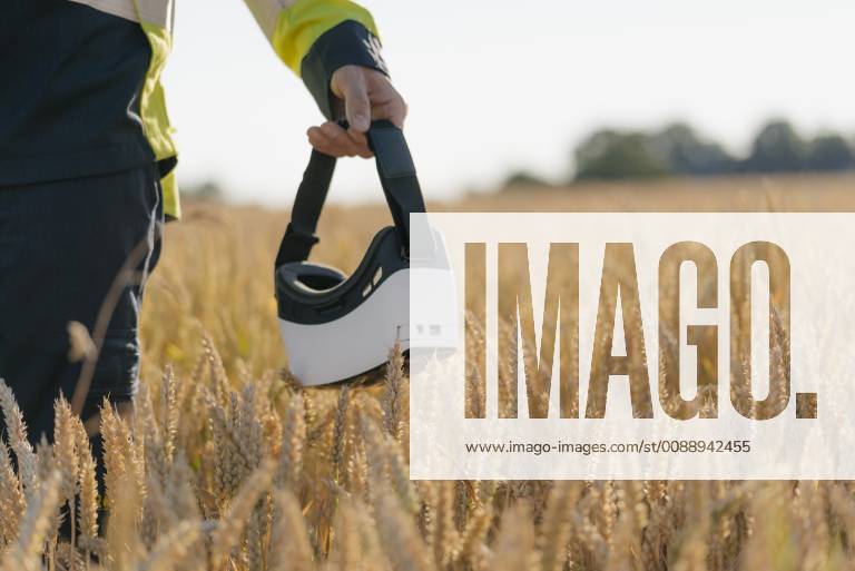 IMAGO Creative: Klimawandel - Zukunft und Innovation Close-up of man in protective workwear and VR glasses in a field model released Symbolfoto GUSF01310