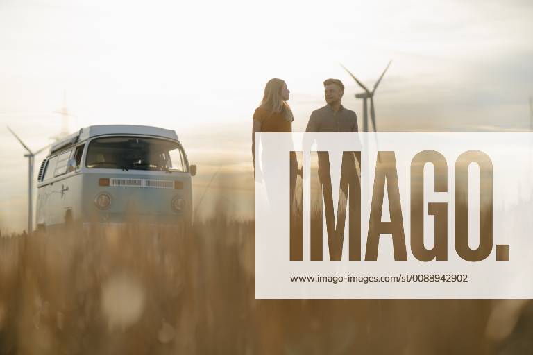 IMAGO Creative: Sommer, Abendspaziergang Young couple hand in hand at camper van in rural landscape at sunset model released Symbolfoto GUSF01648