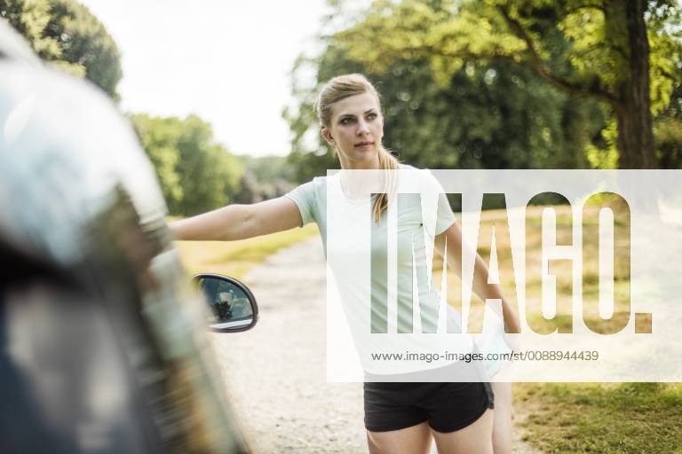 Sportive young woman stretching at a car in a park model released Symbolfoto MOEF01528