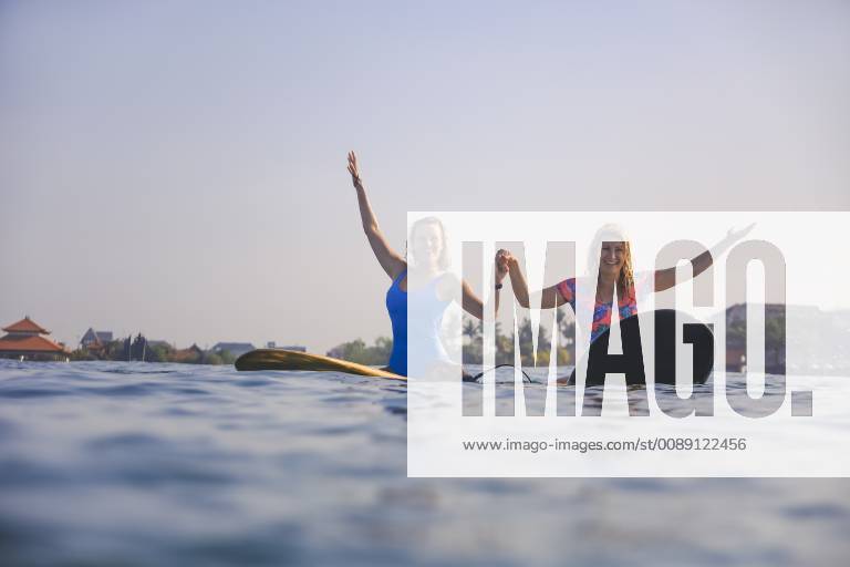 Indonesia, Bali, Batubolong beach, young female surfers raising arms model released Symbolfoto KNTF02458