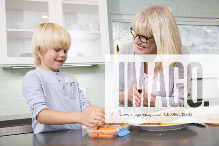 Grandmother and grandson preparing lunch box in kitchen together model released Symbolfoto property released MFRF01101