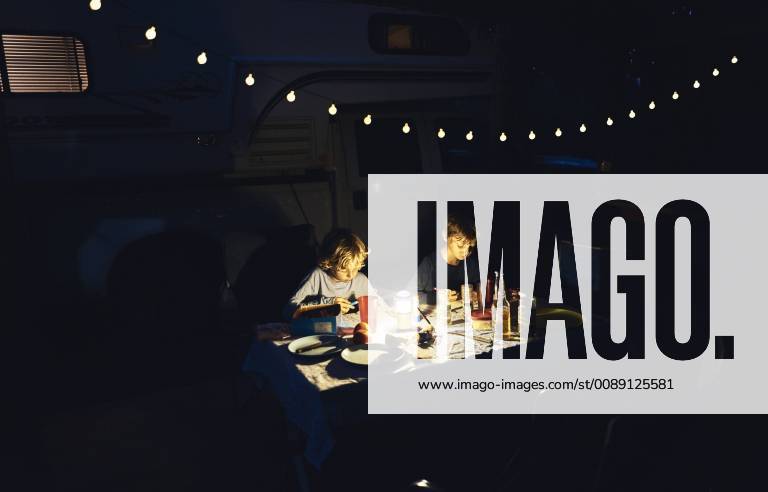 Brazil, Bonito, two boys drawing at camper in the dark model released Symbolfoto property released SSCF00010
