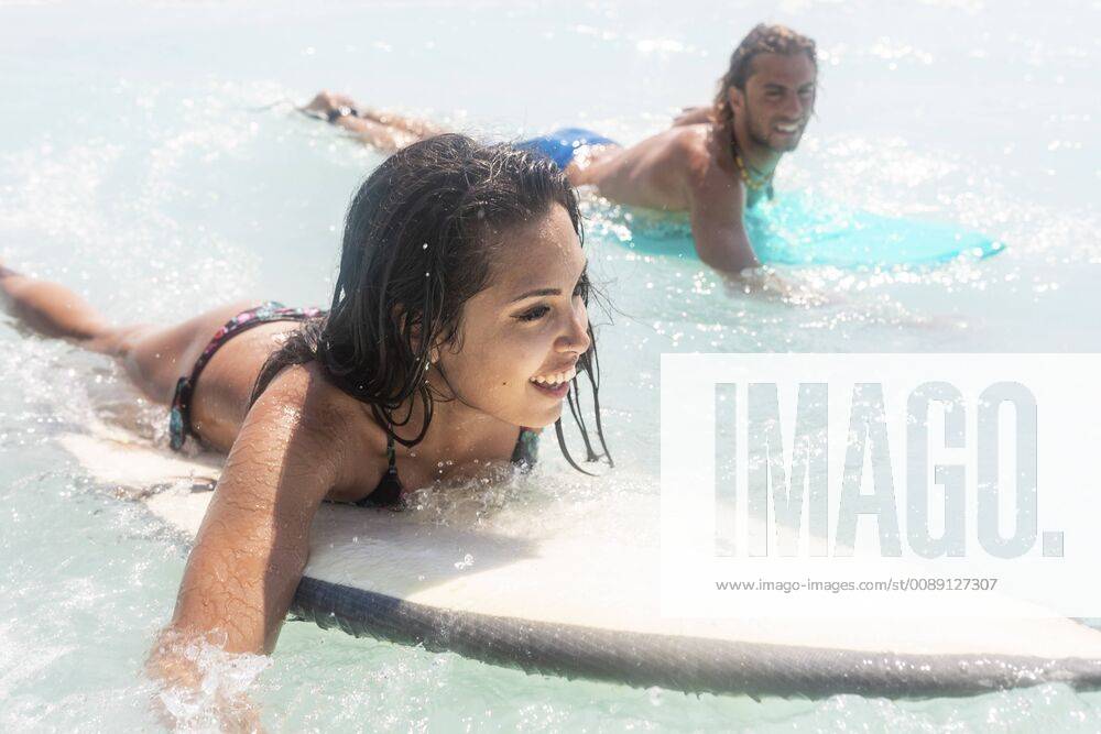Young couple having fun at he sea, surfing model released Symbolfoto WPEF01067
