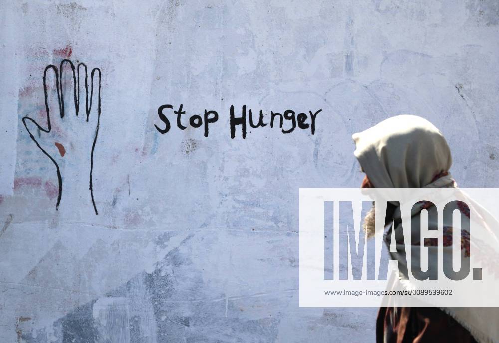 (190221) -- SANAA, Feb. 21, 2019 -- A Yemeni elderly man walks by graffiti showing Stop Hunger on a wall in Sanaa, Yemen, Feb. 21, 2019. A graffiti campaign by Yemeni artists was staged to call for the world s attention on Yemen and the people who are suffering from hunger due to more than four years of war. Mohammed Mohammed) YEMEN-SANAA-GRAFFITI-ANTI-HUNGER nieyunpeng