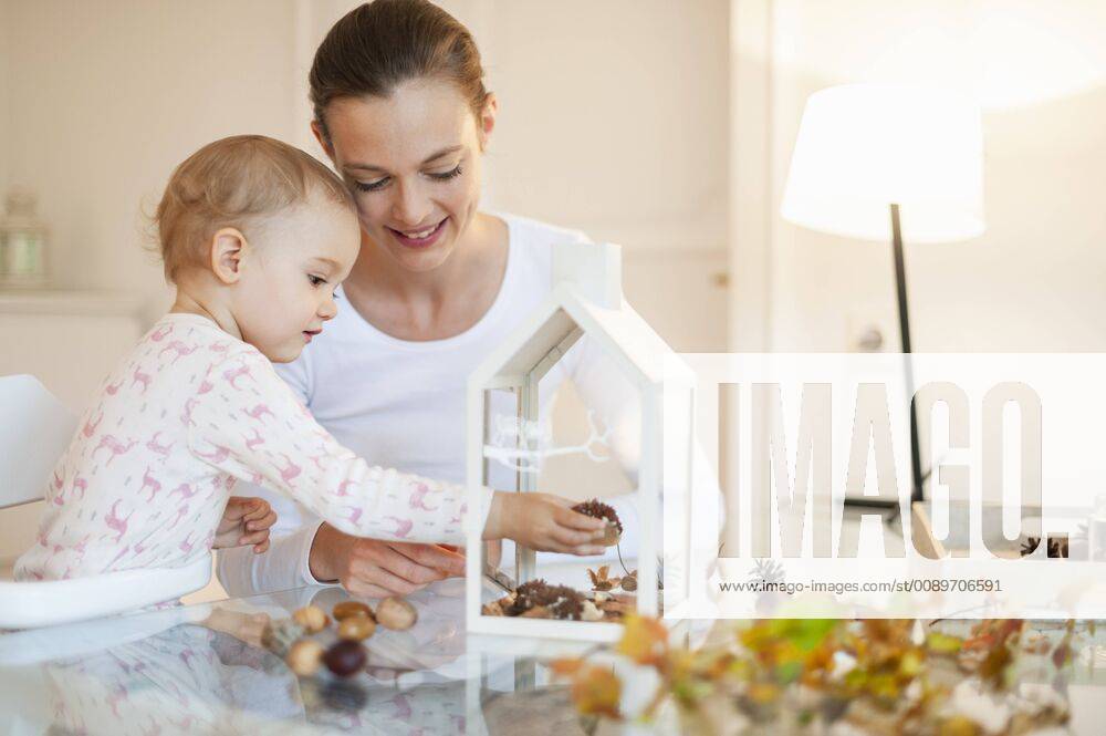 Mother and little daughter tinkering autumnal decorative house at home model released Symbolfoto property released DIGF05576