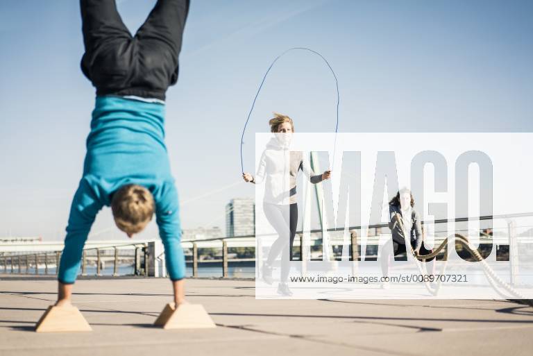 Friends training at the riverside, skipping rope and doing handstand model released Symbolfoto MOEF01667