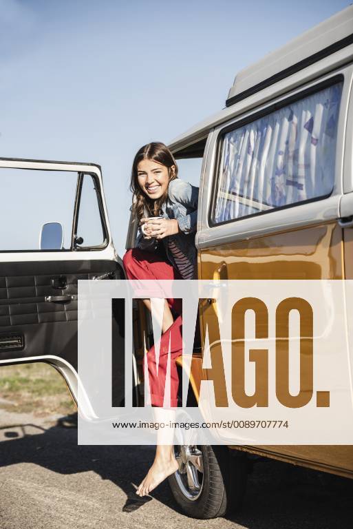 Pretty woman on a road trip with her camper, taking a break, drinking coffee model released Symbolfoto UUF16145