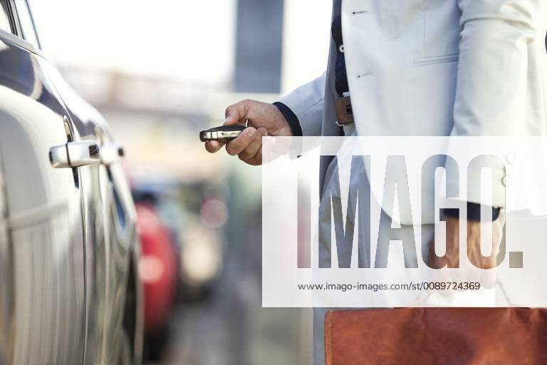 Businessman unlocking his car, close up model released Symbolfoto JSRF00078