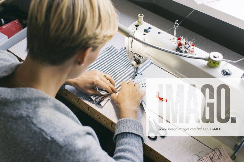 Woman using sewing machine on table in studio model released Symbolfoto property released JUBF00285