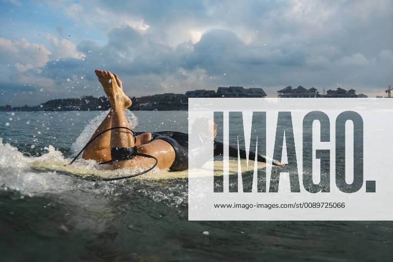 Indonesia, Bali, Canggu, female surfer lying on surfboard model released Symbolfoto KNTF02591