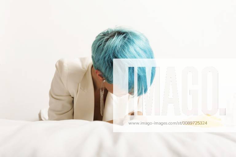 Grunge lesbian woman with blue hair, lying on bed model released Symbolfoto property released ERRF00281