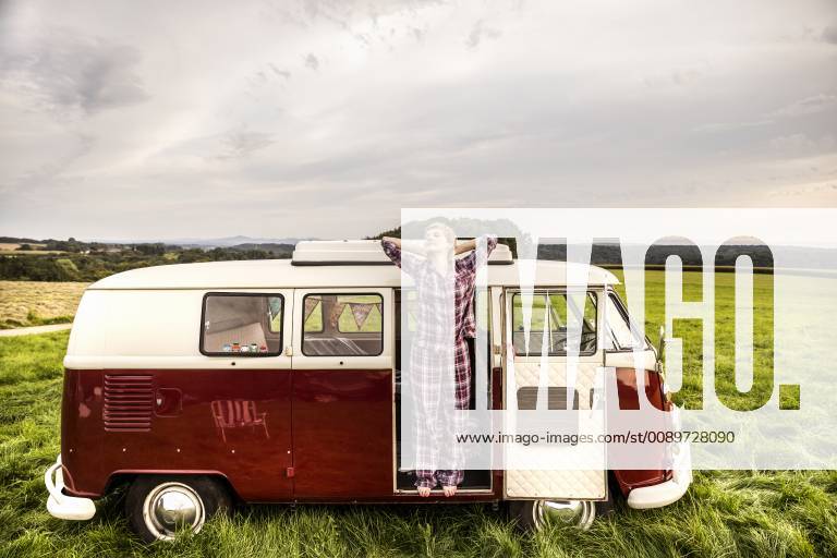 Woman in pyjama stretching in a van in rural landscape model released Symbolfoto property released FMKF04598