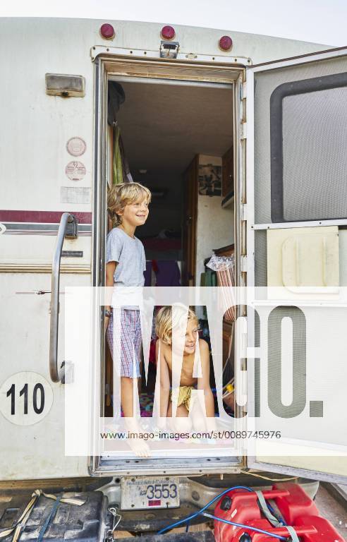 Two smiling boys looking out of door of a camper model released Symbolfoto property released SSCF00080