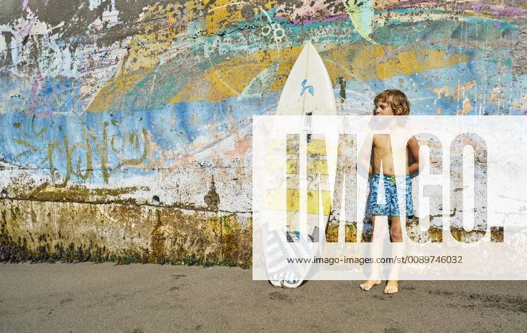 Chile, Pichilemu, boy standing at a colorful wall with surfboard model released Symbolfoto SSCF00123