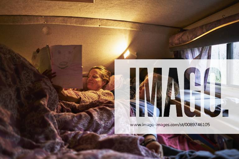 Mother looking at son s drawings lying in bed of a camper model released Symbolfoto property released SSCF00180