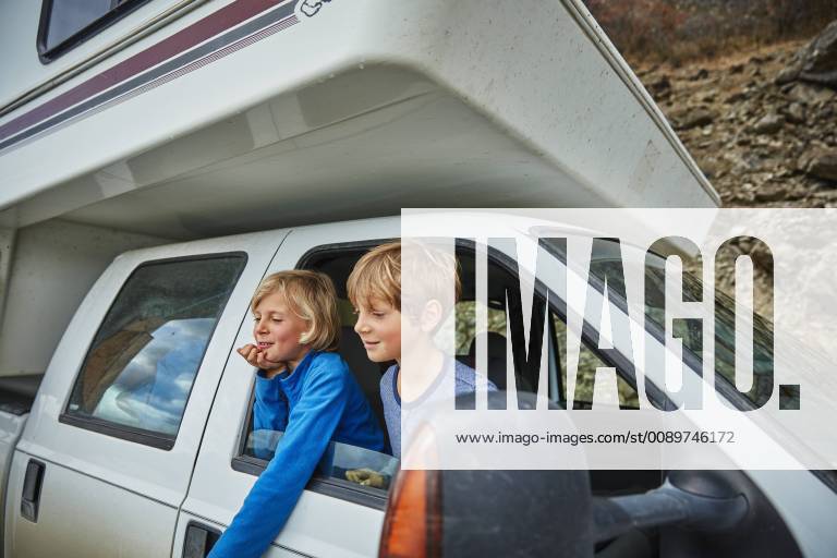 Two smiling boys looking out of window of a camper model released Symbolfoto property released SSCF00241