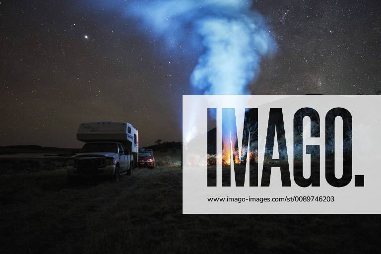 Chile, Tierra del Fuego, Lago Blanco, campfire and people at camper under starry sky at night model released Symbolfoto property released SSCF00272