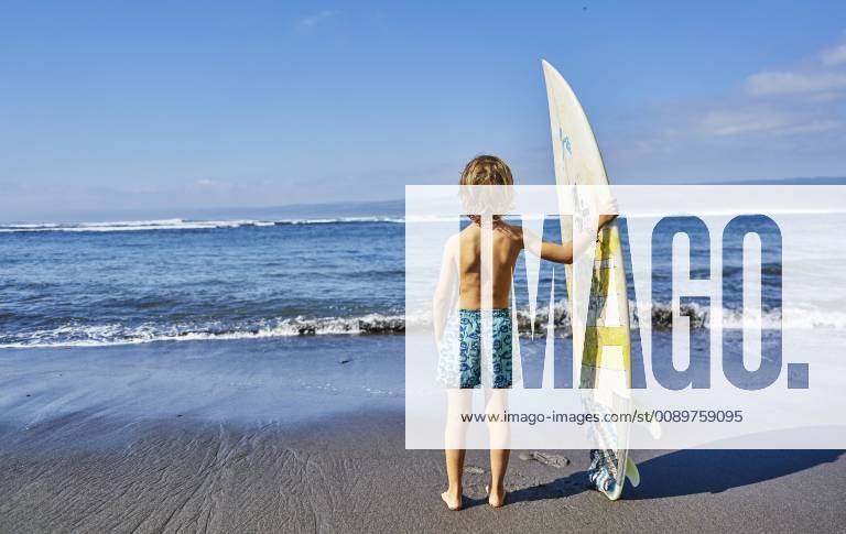 Chile, Pichilemu, boy standing at the sea with surfboard model released Symbolfoto SSCF00121