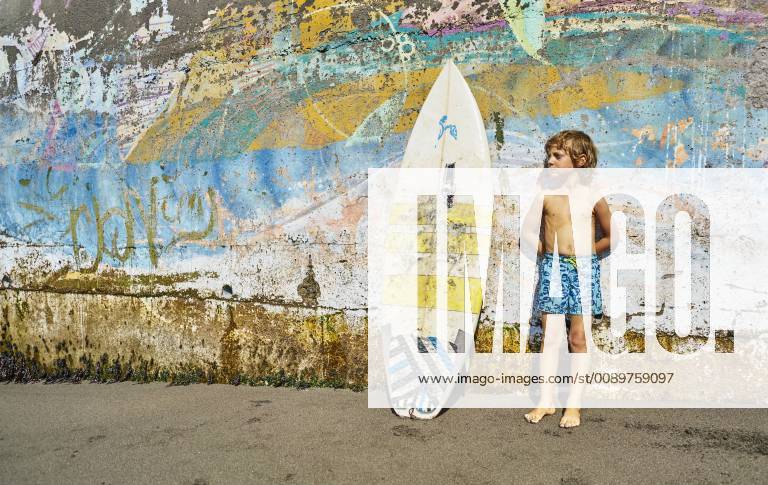 Chile, Pichilemu, boy standing at a colorful wall with surfboard model released Symbolfoto SSCF00123