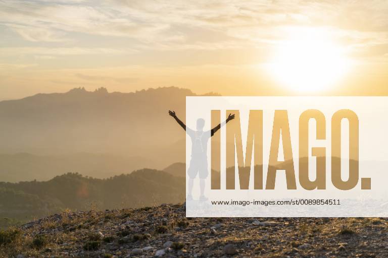 Spain, Barcelona, Natural Park of Sant Llorenc, man hiking and cheering at sunset model released Symbolfoto AFVF01890