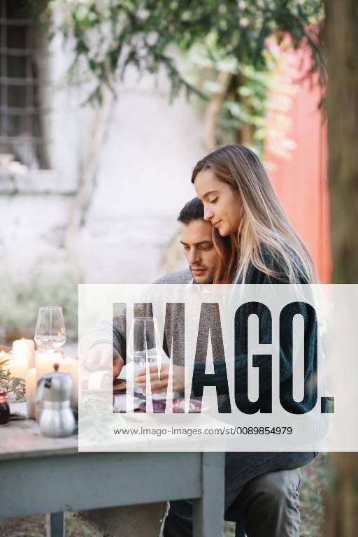 Romantic couple having a candelight meal at garden table model released Symbolfoto ALBF00746