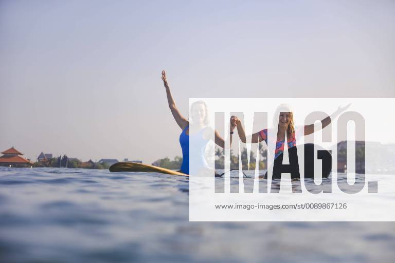 Indonesia, Bali, Batubolong beach, young female surfers raising arms model released Symbolfoto KNTF02458