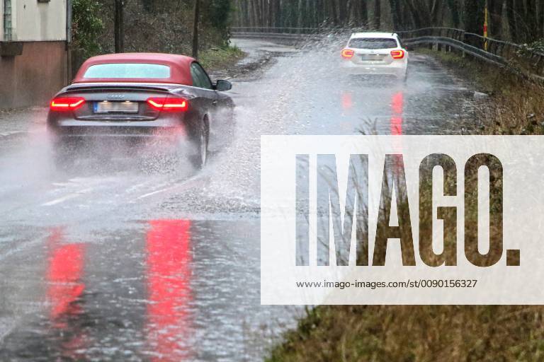 Dangerous road conditions during heavy rain The water from a road flooded after heavy rain is torn into the air by the cars and causes many drivers to be terrified Essen Nordrhein Westfalen Germany Deutschland Überruhr