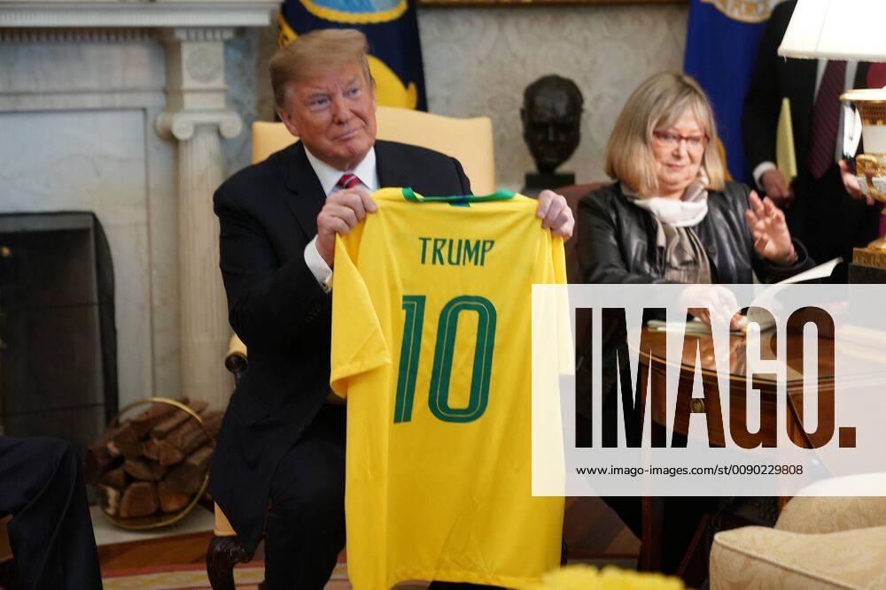 President Donald Trump holds up a Brazilian national soccer team jersey after it was given to him by Brazilian President Jair Bolsonaro in the Oval Office of the White House prior to meetings in Washington, DC on March 19, 2019. WAX20190319106 CHRISxKLEPONIS