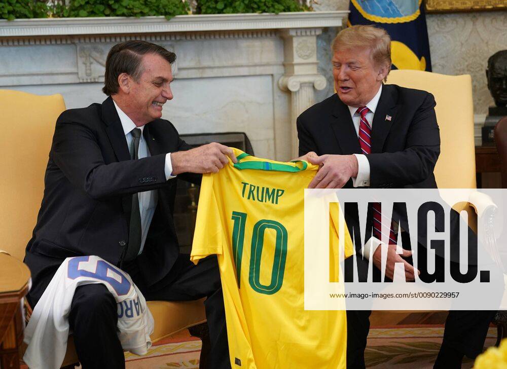 President Donald Trump receives a Brazilian national soccer team jersey Number 10 that was given to him by Brazilian President Jair Bolsonaro in the Oval Office of the White House prior to meetings in Washington, DC on March 19, 2019. WAX20190319111 CHRISxKLEPONIS