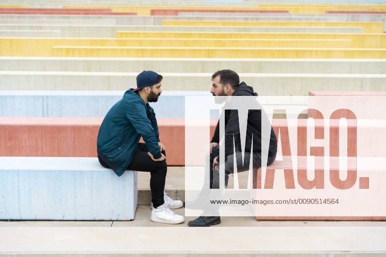 Two friends sitting on benches looking at each other model released Symbolfoto AFVF02168